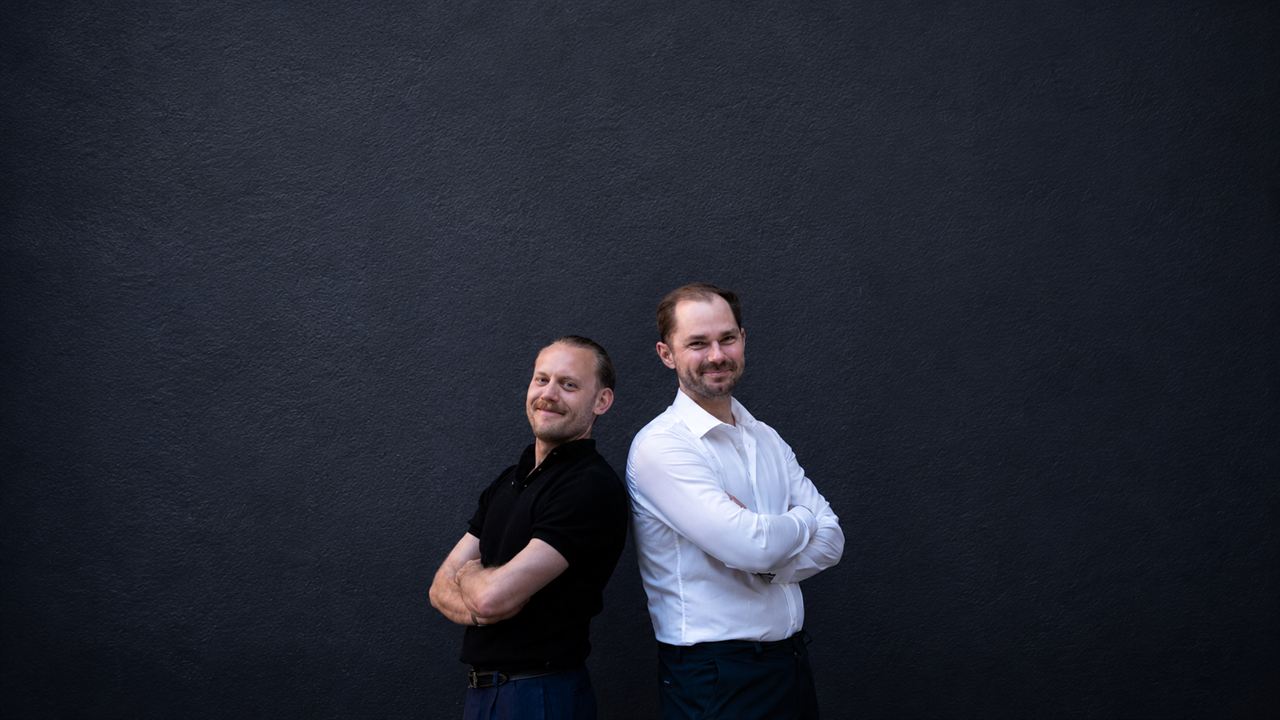 Daniel Straub und Henning Baumann vor dunkler Wand
